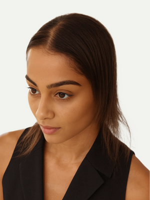 Woman wearing a black sleeveless blazer against a white background