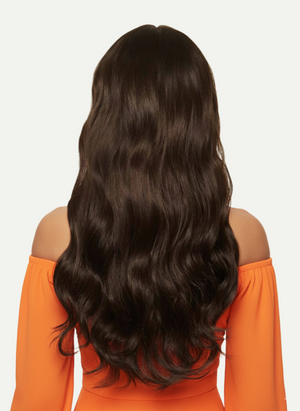 Person wearing an orange off-shoulder top with long, wavy dark hair on a light gray background